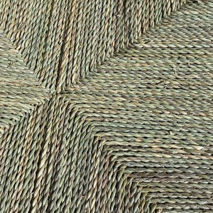 Pode incluir: Close-up de um assento tecido feito de fibras naturais verdes. O assento &eacute; tecido em forma de diamante e tem um aspecto r&uacute;stico e natural.
