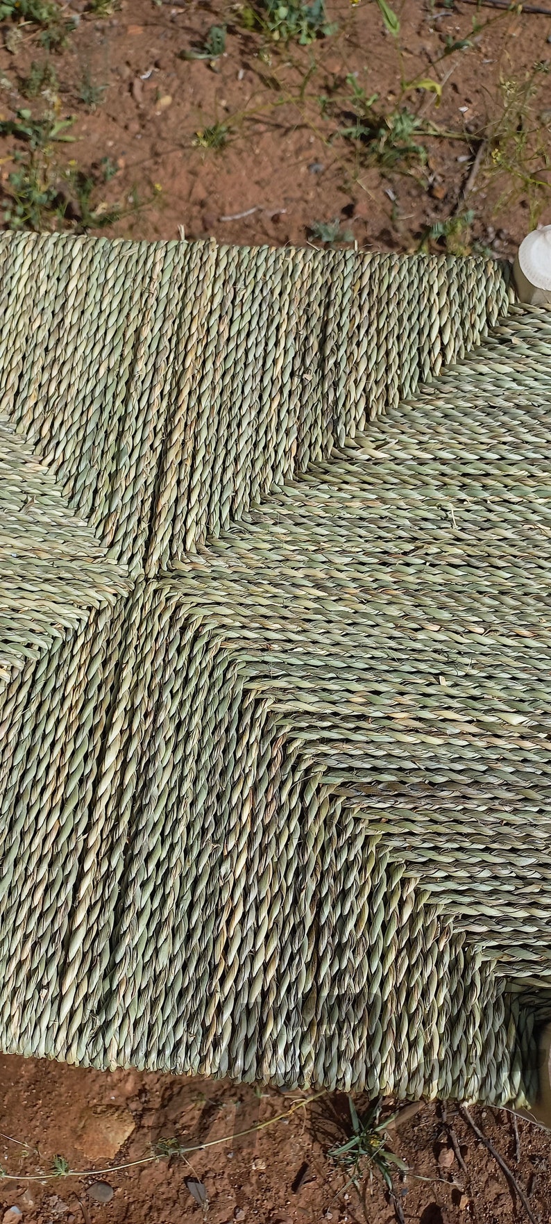 Pode incluir: Close-up de um assento tecido feito de fibras naturais verdes. O assento &eacute; tecido em forma de diamante e tem um aspecto r&uacute;stico e natural.