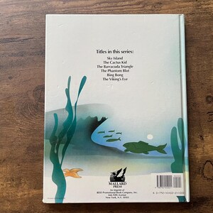 Op de afbeelding: Een lichtgekleurde boekomslag met een onderwaterillustratie met groen zeewier, een grote groene vis, kleinere vissen en een zeester. De tekst luidt: Titles in this series: Sky Island, The Cactus Kid, The Barracuda Triangle, The Phantom Blot, Bing Bong, The Viking's Eye en Mallard Press.