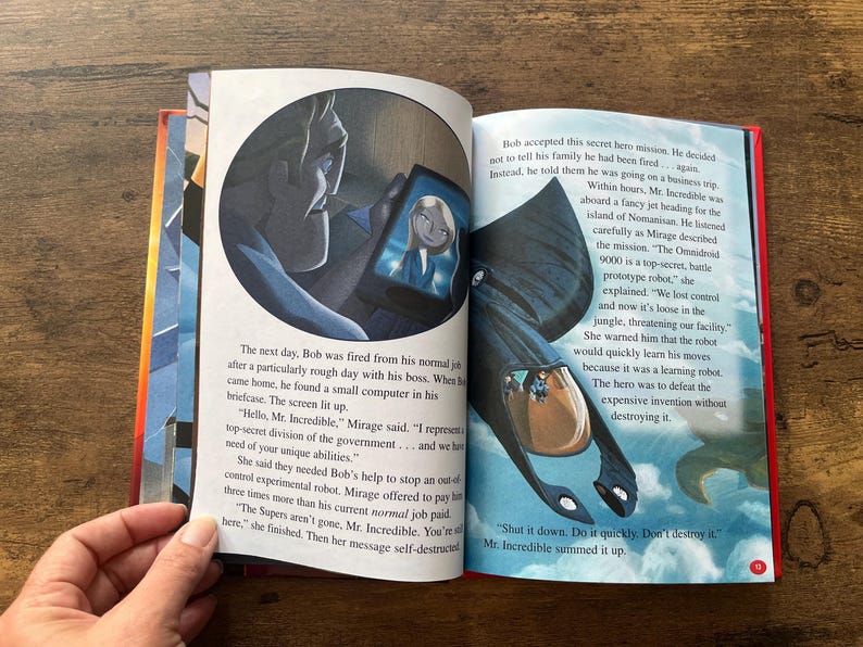 May include: An open children's storybook featuring The Incredibles. The left page shows a character looking at a tablet screen with a woman's face. The right page displays a black robotic vehicle flying over clouds with printed English text.