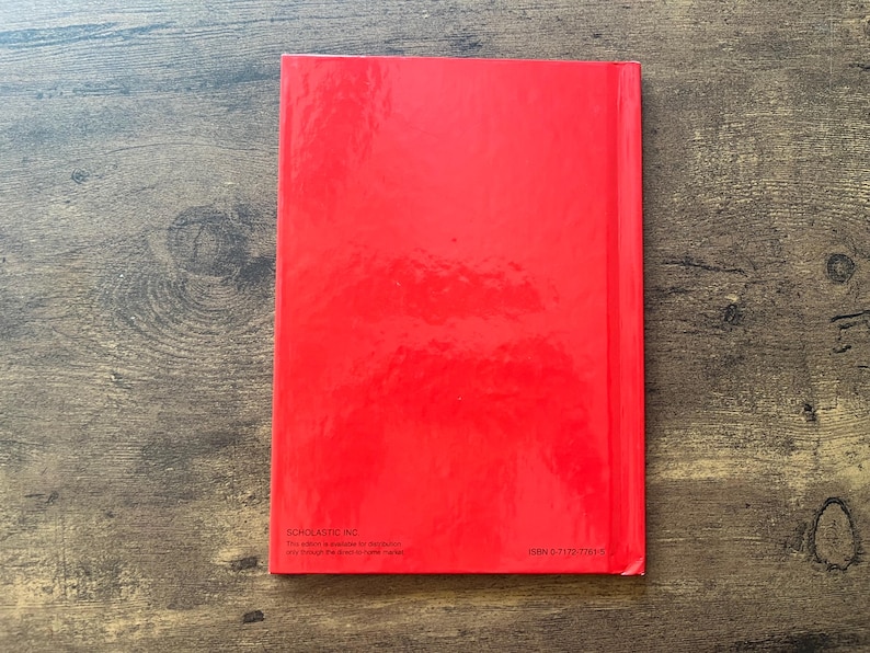 May include: A rectangular book with a solid, glossy red cover. The bottom left corner features the text Scholastic Inc. and a small paragraph of text, while the bottom right corner displays the ISBN number 0-7172-7751-9 in black font.