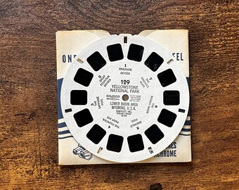 May include: A circular white View-Master reel featuring Yellowstone National Park, Lower Basin Area, Wyoming, U.S.A. The reel contains seven pairs of image frames and text labels for sites including Riverside Geyser and Sapphire Pool.