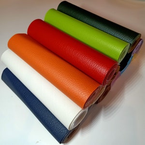 May include: A stack of colorful faux leather rolls in various colors, including orange, red, green, blue, and white. The rolls are arranged in a fan shape, with the orange roll at the top and the white roll at the bottom.