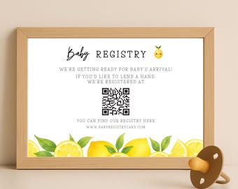 Puede incluir: Un anuncio de registro de bebé enmarcado con el texto "Baby Registry" y una ilustración de limón. El anuncio incluye un código QR y la dirección del sitio web www.babyregistrycard.com. Un chupete marrón está en primer plano.