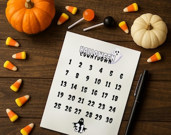 May include: A Halloween countdown calendar with a ghost graphic, surrounded by candy corn, pumpkins, and lollipops. The calendar counts down from 1 to 30. A black pen rests on the wooden surface.