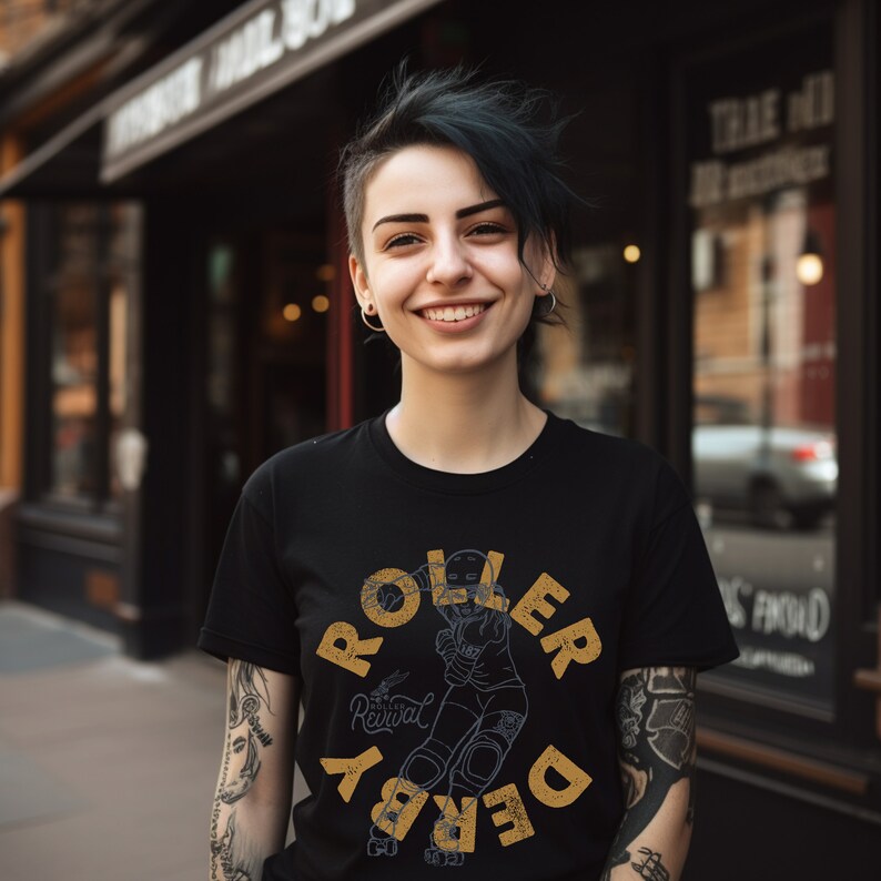 Op de afbeelding: Een persoon draagt een zwart T-shirt met een gele afbeelding van een roller derby-speler. De afbeelding zegt "Roller Derby" en "Revival" in een vintage lettertype.