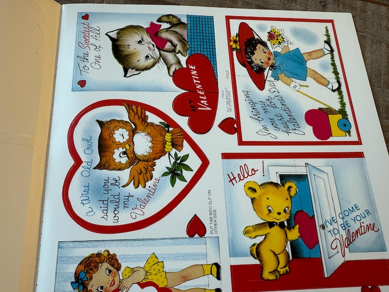 May include: A sheet of vintage Valentine's Day cards with illustrations of a kitten, owl, girl, and teddy bear. The cards have red heart accents and text such as "To the Sweetest One of All" and "I'm bringing my heart for Valentine's Day."