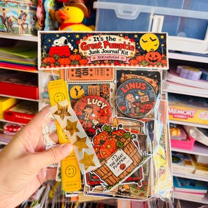 Puede incluir: Una bolsa de pl&aacute;stico transparente que contiene un kit de diario basura It's the Great Pumpkin. El kit incluye ef&iacute;meros de papel, un bot&oacute;n de Lucy, un bot&oacute;n de Linus, boletos amarillos con caritas sonrientes, pegatinas de estrellas doradas y un recorte.