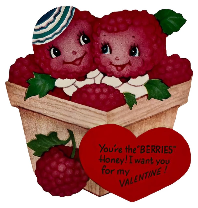 May include: A vintage Valentine's Day card showing two raspberry characters in a wooden basket. One raspberry wears a striped hat. A red heart with the text "You're the BERRIES Honey! I want you for my VALENTINE!" is attached.