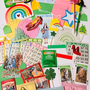 May include: A collection of Wizard of Oz themed ephemera, including playing cards, bingo cards, paper cutouts, and play money. The image features a rainbow, ruby slippers, and a tea bag.