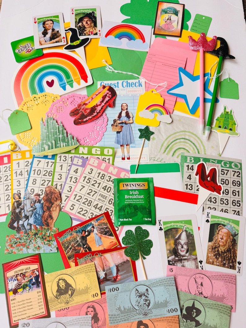 May include: A selection of Wizard of Oz themed items, such as playing cards, bingo cards, and paper cutouts. The image includes a rainbow, ruby slippers, and a tea bag of Irish Breakfast tea.