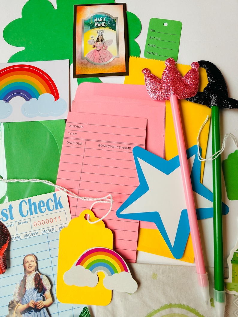 May include: A colourful assortment of craft items, featuring a pink crown wand, a black witch hat wand, a rainbow, and a star. Also included are library cards, tags, and a vintage postcard with the words "Magic Wand".