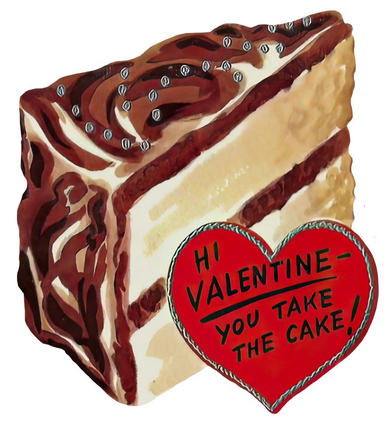 May include: A slice of cake with chocolate icing and silver sprinkles, beside a red heart-shaped card. The card reads "Hi Valentine - You Take The Cake!" in black text. The cake has a light brown and white interior.