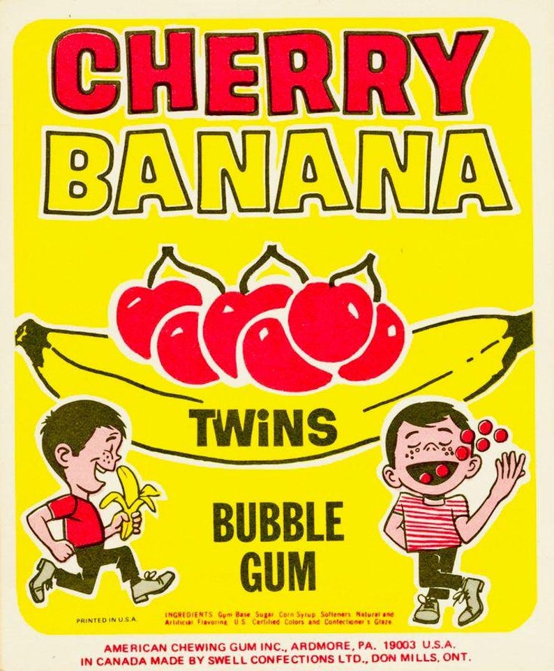 Puede incluir: Una etiqueta amarilla vintage para "Cherry Banana Twins Bubble Gum". La etiqueta presenta texto rojo e ilustraciones de cerezas, pl&aacute;tanos y ni&ntilde;os de dibujos animados. El texto "Printed in U.S.A." es visible.