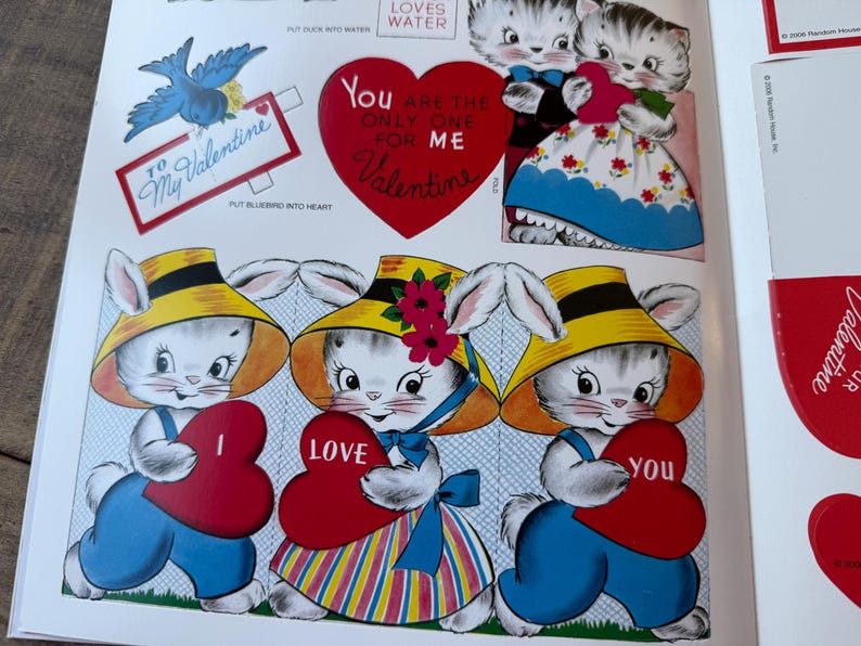 May include: Vintage Valentine's Day cutouts with cartoon kittens and bunnies. The illustrations include a blue bird, a heart-shaped message that reads "You are the only one for me Valentine", and other heart-shaped cutouts. The characters are holding heart-shaped cards.