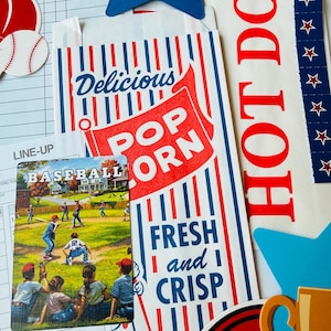 Op de afbeelding: Een verzameling papieren ephemera met een popcornzak met rode en blauwe strepen en de tekst Delicious POPCORN FRESH and CRISP, een honkbalspelkaart, een HOT DOG-bord, een blauwe steruitsparing en een honkbal-scoreformulier.