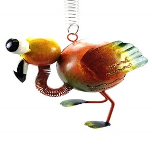 May include: A whimsical metal flamingo ornament with a spring attached to the top. The flamingo is orange, yellow, and green with a black eye and a white pupil. The flamingo's neck is a spring.