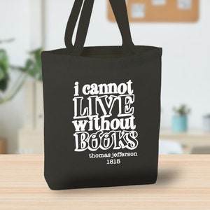 May include: Black canvas tote bag with white text that reads "I cannot live without books" and "thomas jefferson 1815".