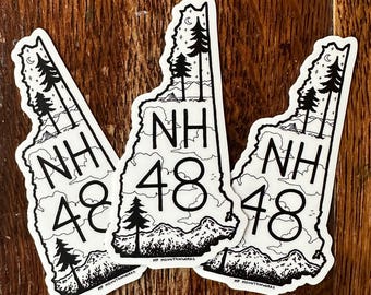 May include: Three white stickers shaped like the state of New Hampshire, with a black and white mountain and tree design. Each sticker has the letters "NH" and the number "48". The text "MP Mountainworks" is printed at the bottom of each sticker.