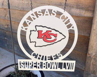 Könnte beinhalten: Weißes Metallschild mit einem rot-weißen Logo der Kansas City Chiefs und dem Text "Kansas City Chiefs Super Bowl LVII".