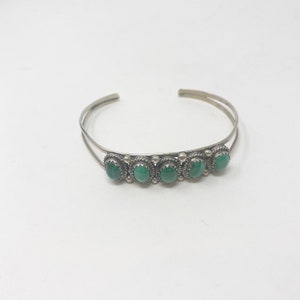 May include: A silver bracelet with five green malachite stones set in silver.