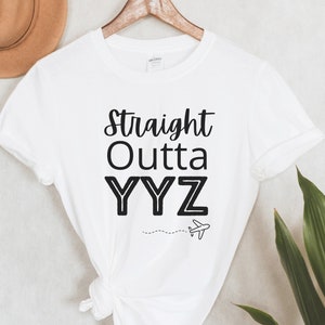 May include: White t-shirt with black text that reads "Straight Outta YYZ" with a small airplane graphic below the text.