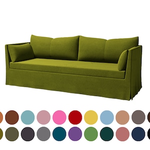 Può includere: Un divano verde con schienale capitonné e gonna. Il divano ha due cuscini ed è realizzato in un tessuto morbido e testurizzato.