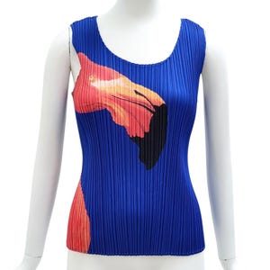 Peut inclure: Un haut sans manches plissé d'un bleu roi vibrant, orné d'un grand motif graphique stylisé représentant une tête de flamant rose dans des tons orange, rose et noir. Le vêtement présente une encolure ronde et un ourlet droit, avec une texture plissée en accordéon sur toute la surface.