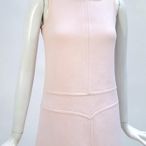 Puede incluir: Vestido rosa p&aacute;lido sin mangas con cuello redondo. El vestido presenta costuras verticales en la parte delantera y una falda sutil en forma de A. El vestido se exhibe en un maniqu&iacute;.