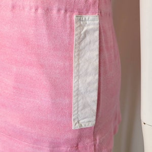 May include: A pink cotton t-shirt with a white patch pocket on the side.