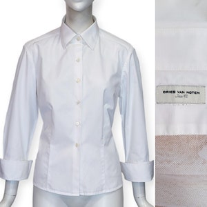 May include: White long-sleeved button-down shirt with a fitted silhouette and a small label that reads "DRIES VAN NOTEN Size 42".