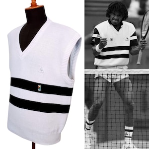 Puede incluir: Jersey blanco sin mangas con rayas negras y un pequeño logotipo triangular. El jersey es similar al que lleva un jugador de tenis en una foto en blanco y negro.