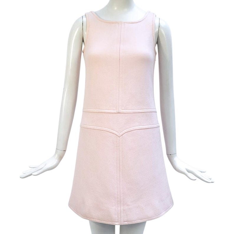Puede incluir: Vestido rosa p&aacute;lido sin mangas con cuello redondo y corpi&ntilde;o entallado. El vestido presenta una costura decorativa en la parte delantera y una cintura decorativa. La falda es de l&iacute;nea A y el vestido se exhibe en un maniqu&iacute;.