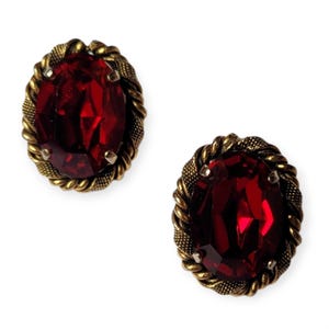 May include: A pair of red gemstone earrings with gold-toned settings. The settings have a rope-like design.