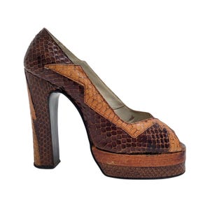 Könnte beinhalten: Vintage Peep-Toe-Pumps mit Plateau in braunem und beigefarbenem Kunstschlangenleder. Der High-Heel-Schuh hat einen klobigen Absatz und eine Plateausohle. Der Schuh hat ein geometrisches Design auf dem Obermaterial und der Ferse.