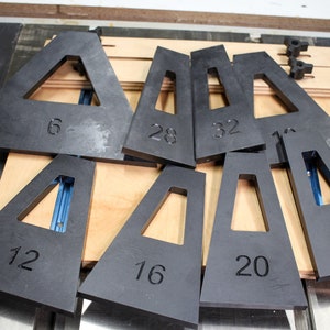 May include: A set of nine black plastic triangles with different sized openings. Each triangle is labeled with a number: 6, 12, 16, 20, 24, 28, 32, 1, and 1.