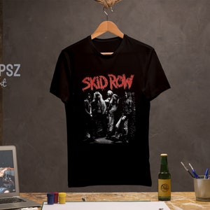 May include: Black cotton t-shirt with a white and red graphic print of the band Skid Row. The band members are pictured in black and white, with the band name in red.