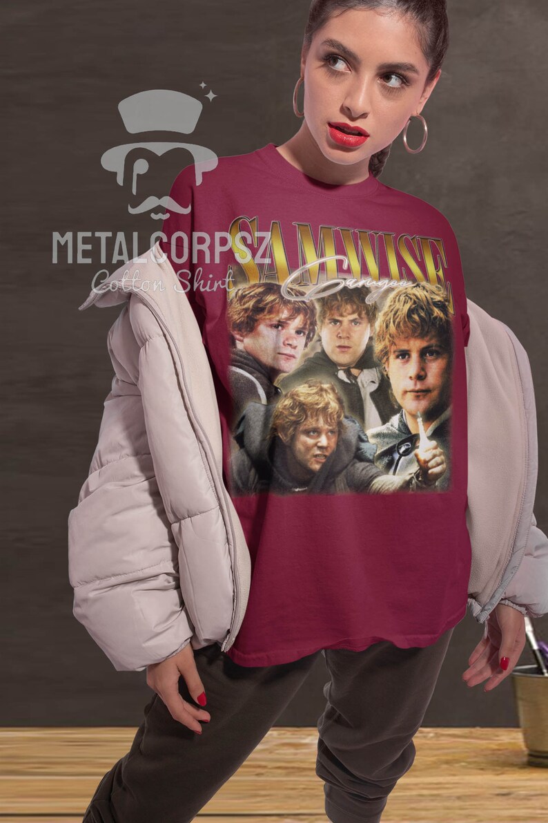 May include: A maroon t-shirt with a vintage-style graphic of Samwise Gamgee from the Lord of the Rings. The graphic features four images of Samwise Gamgee in different poses. The text "Samwise Gamgee" is printed in gold letters above the graphic.