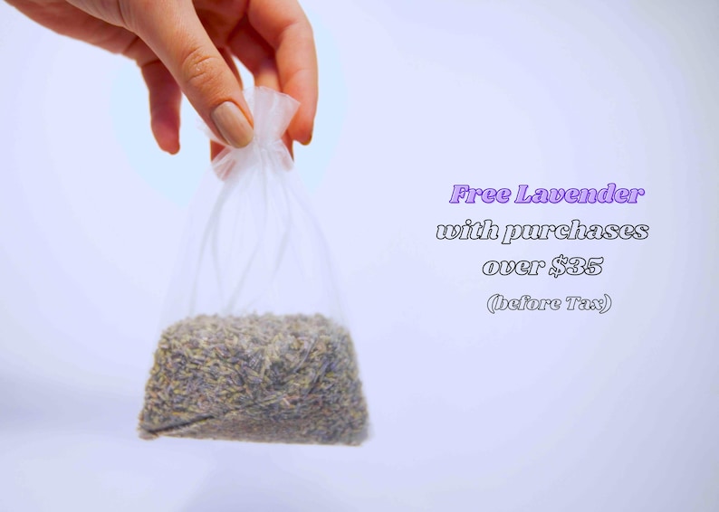 May include: A clear plastic bag filled with dried lavender buds. The bag is held by a hand against a white background. Text in the image reads "Free Lavender with purchases over $35 (before Tax)".