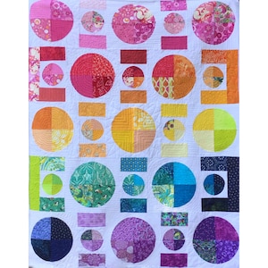 Puede incluir: Una colcha con fondo blanco y una cuadrícula de círculos y rectángulos de tela multicolor. Los círculos están divididos en cuatro cuadrantes con diversos patrones y tonos, incluyendo rosa, naranja, amarillo, verde, azul y morado.