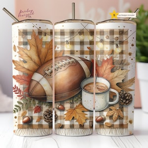 Puede incluir: Un vaso blanco con temática otoñal, con un balón de fútbol americano, hojas de otoño y una taza de café. El diseño incluye un patrón de cuadros y elementos decorativos como bellotas y piñas. El vaso tiene una pajita.