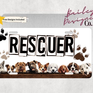 May include: White metal license plate with the word "RESCUER" in black block letters with a distressed look.  Nine paw prints are scattered around the word.  A row of eight dogs of different breeds are peeking over a brown wooden plank at the bottom of the plate.  The text "Bailey Designed Co." is in pink script at the top right corner of the plate.