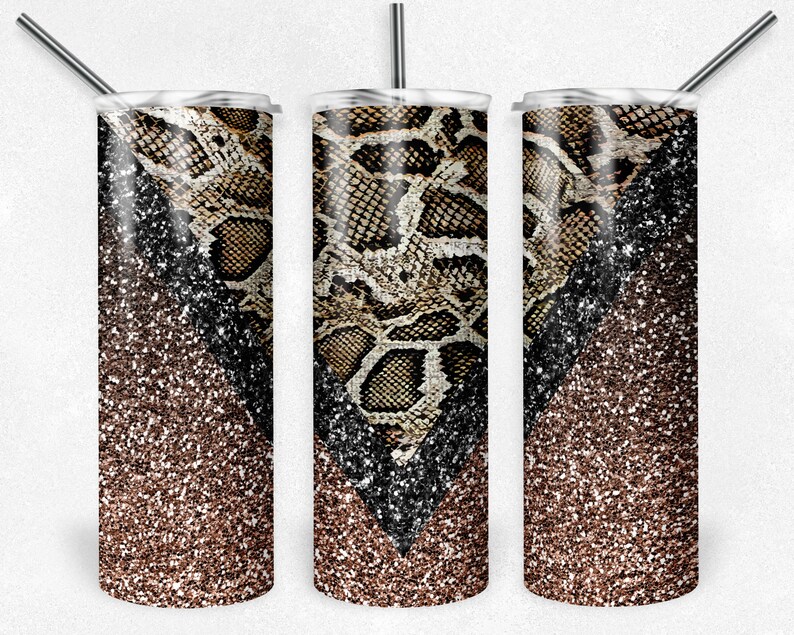 Pu&ograve; includere: Tre bicchieri in acciaio inossidabile con coperchi e cannucce. Il design presenta un motivo a pelle di serpente marrone e beige, contrastato da un gradiente di glitter neri e marroni. I bicchieri sono progettati per bevande fredde.