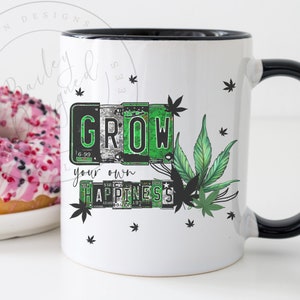Op de afbeelding: Witte keramische mok met een zwarte rand en handvat. De mok heeft een groen cannabisbladontwerp met de tekst "GROW your own HAPPINESS" in een vintage kentekenplaat stijl.