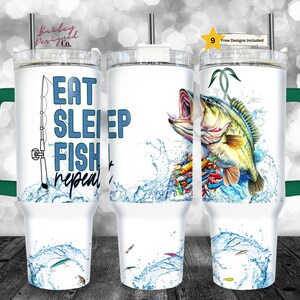 Pode incluir: Um copo branco com uma alça verde e um canudo. O copo tem um desenho de um peixe saltando para fora da água com uma vara de pesca e o texto "Eat Sleep Fish Repeat".