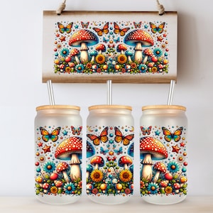 May include: Three frosted glass tumblers with wooden lids and metal straws, each adorned with a vibrant design of mushrooms, butterflies, and flowers. A matching wooden sign hangs above, featuring the same whimsical artwork.