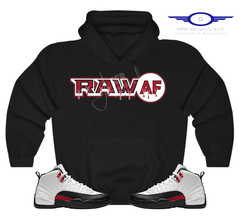 Puede incluir: Sudadera negra con un gr&aacute;fico "RAW AF" rojo y blanco y un par de zapatillas blancas y negras con detalles rojos.