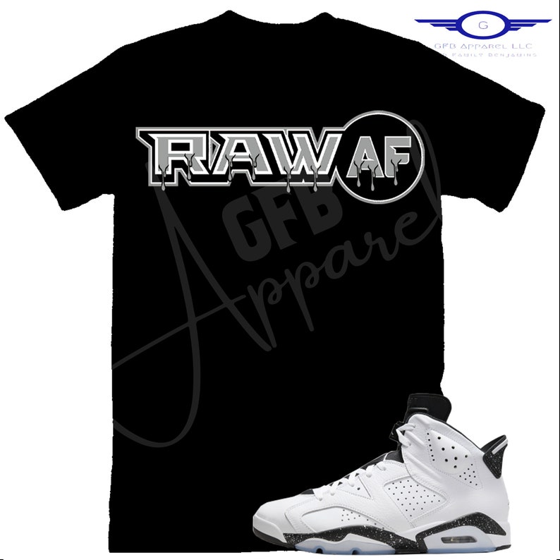 May include: Black t-shirt with the text "RAW AF GFB Apparel" in white and grey. A white and black sneaker with black laces is in the bottom right corner of the image.