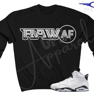 May include: Black sweatshirt with a white graphic that says "RAW AF" and a white and black trainer.