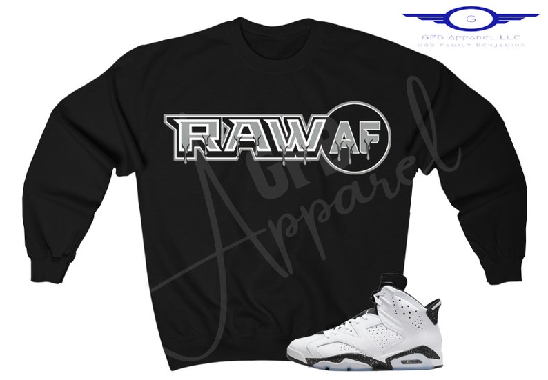 May include: Black sweatshirt with a white graphic that says "RAW AF" and a white and black trainer.